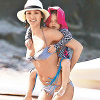 身材Fit爆的謝茜嘉，背着女兒於沙灘玩耍。（東方IC圖片）