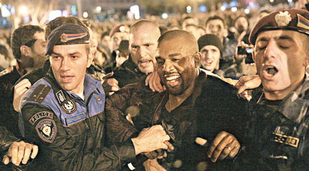 成身濕晒的Kanye笑住被警察帶走。（東方IC圖片）
