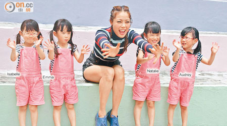 祖兒穿上樽領長袖衫與來自台灣的四胞胎妹妹拍廣告。