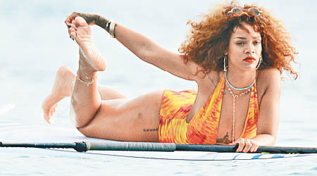 Rihanna「化行妝」在浮板上拉筋熱身。（東方IC圖片）