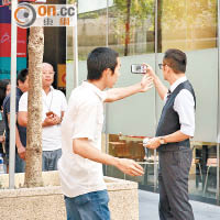 吳啟華被大批市民圍觀，他不禁拿出手機影低熱鬧場面。