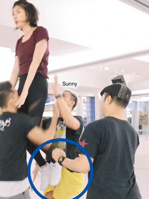 Sunny Wong從後抱起陳慧琳，之後竟被她踢中下體（圓圈示）。