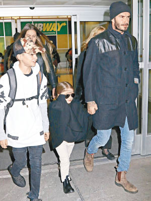 碧咸拖住穿黑色斗篷的夏柏，與兒子齊齊步出機場。（東方IC圖片）