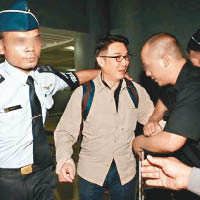 劉松仁一出機場，被保安像「押犯」般對待。
