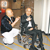 黃偉文親手為盧國沾推輪椅。