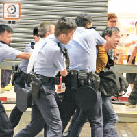 另一名男途人突然發難，激動向警察指罵及飛遮，被多名警察制服。