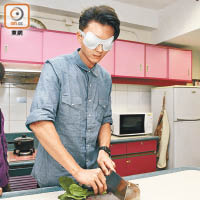 王浩信蒙住眼切菜，體驗失明人士感受。