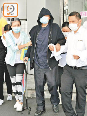 上月劉鑾雄（黑衫）在甘比的陪同下入院。