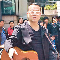 歐陽震華拍攝街頭演唱的場面，惹來途人圍觀。