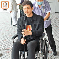 羅孝勇坐住輪椅出院。