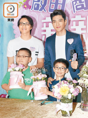 吳業坤與羅天宇陪小朋友整禮物。