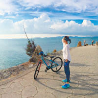 李旻芳以單車代步，遊覽美景。