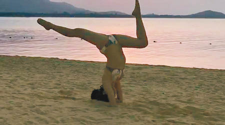 麥明詩在沙灘上玩瑜伽，勁考平衡力。