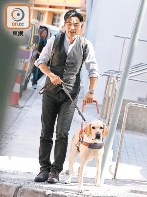 任達華在新片中扮演盲人，昨日拖着導盲犬演出。