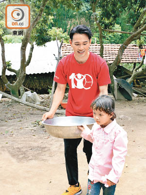 王梓軒與養女一起打水。
