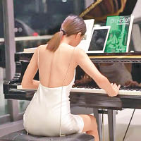 穿露背裝的李元玲優雅彈琴。
