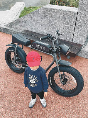 兒子戴上紅色Cap帽，與余文樂一起踩單車。