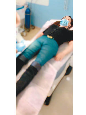 鄧萃雯躺在病床上，準備接受醫護的治療。