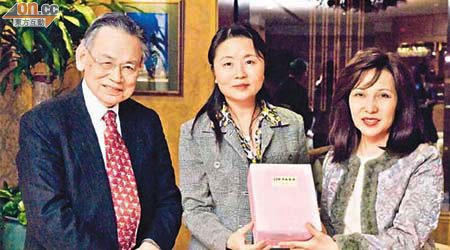 新地郭氏基金執行董事郭婉儀（右）及董事鄺準（左）向中國教育部嘅代表送贈紀念品。