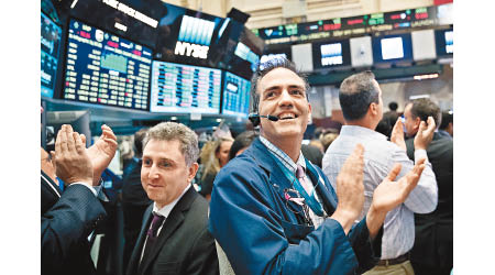 美股三大指數本月相繼創收市新高，交易員綻露笑容。（資料圖片）