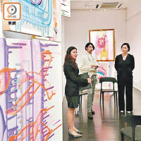 藝術家在畫廊舉辦畫展，與客人交流。