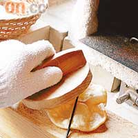 想餅燒出來靚啲，就要用木頭將彎曲了的餅壓平。