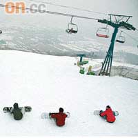 一群單板玩家在高級滑雪道嚴陣以待，雪道好像深不見底似的。
