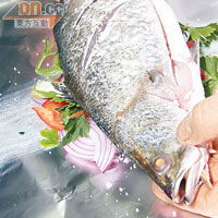 在一邊魚身，用刀輕切3下，在切口位放入海鹽；將魚放上錫紙，向魚身倒入約2湯匙的白酒及橄欖油。