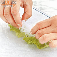 用濕毛巾墊底，以水輕抹越南米紙的表面令其變得軟身。檬粉浸凍水約20分鐘至軟身，米紙先向上摺起四分一，放上生菜葉、適量檬粉、酸菜及薄荷葉。