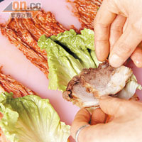 Step 3 把泡菜逐塊攤平，放上生菜、蘿蔔絲及豬肉片。