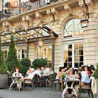 當地人喜歡於白天下坐在酒店Brasserie l'Europe餐廳的露天茶座，對着大劇院用膳。