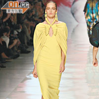 貼身鮮黃色長裙外披一件猶如蝴蝶伏在身上的cape，款式獨特。