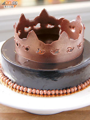 La Couronne  $320/磅（需預訂）<BR>用上法國Valrhona 80%朱古力慕絲、朱古力蛋糕和圓粒珠珠做裝飾，再加上朱古力小王冠，不僅高貴，更是朱古力癡的至愛。