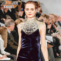 簡潔的天鵝絨長裙以誇張的頸飾作配襯，既是頸鏈，亦是晚裝的一部分，清麗脫俗。