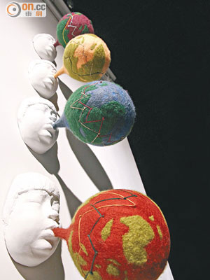 康雅筑作品：《吹氣》<br>不同顏色、樣貌的地球被吹脹了，球體表面是彎彎曲曲的股市走勢圖，寓意經濟發展難以猜測。