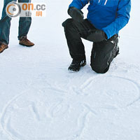 在冰天雪地下，導師在冰面畫圖講解「8」字路線。