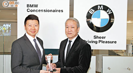 寶馬汽車（香港）銷售及巿場部總經理劉家輝（左）對獲獎感到高興，獎項由資深媒體人狄港生頒發。