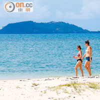 島上偶見外國遊客在海邊散步閒聊，十分寫意。