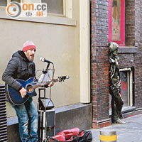 Matthew Street街頭賣唱的，也選唱Beatles樂曲，旁邊的Lennon像似是在傾聽。