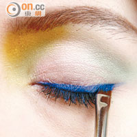 在眼窩中央加上蜜桃色眼影作Highlight，然後以藍色眼線膏畫出一條修長眼線。
