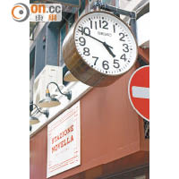 門外掛有外國車站常見的時鐘，且特意調快5分鐘，以諷刺當地人不守時的習慣。