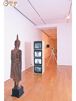 《伸手立佛》是藝術家臨終前1年的創作，站立的佛像與閉路電視呈對望狀態，很有禪味。