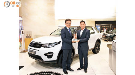 除了「最卓越歐洲動感轎車」，英倫汽車有限公司（British Motors Limited）助理總經理劉景文（左）再從香港著名賽車運動員方駿宇手上，領取「最卓越歐洲SUV」獎項。