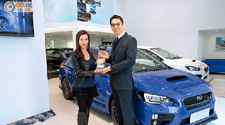 意美汽車（香港）有限公司總經理陳沛成（右）對今次獲獎深感高興，並從香港著名賽車運動員楊嘉怡手上接過「最卓越日韓跑車」獎項。