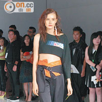 黑色鴛鴦袖cropped top搭黑色褲，橙色腰帶加強色彩效果。