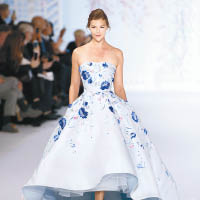 連身裙以人手逐一釘上藍色花卉刺繡，加入誇張的裙襬，更添美感。