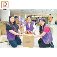 康泰旅行社董事長黃士心拿督（中）一同參與義務工作，幫手包裝「膳糧食物包」。