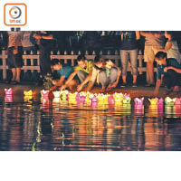 夜幕下的秋盆河依然熱鬧，遊客都喜歡在河邊放水燈祈福。