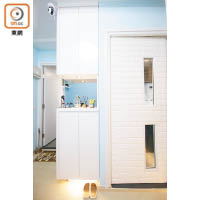 廚房門用上凹凸磚面牆貼，呼應廳堂布置，旁邊的鞋櫃採用懸空設計，並配置燈槽，加強空間感。