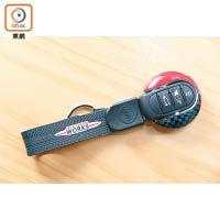匙扣連保護套<br>專為MINI專屬的圓形車匙設計，隨附印有John Cooper Works徽飾的黑色帶扣。<br>售價：$540